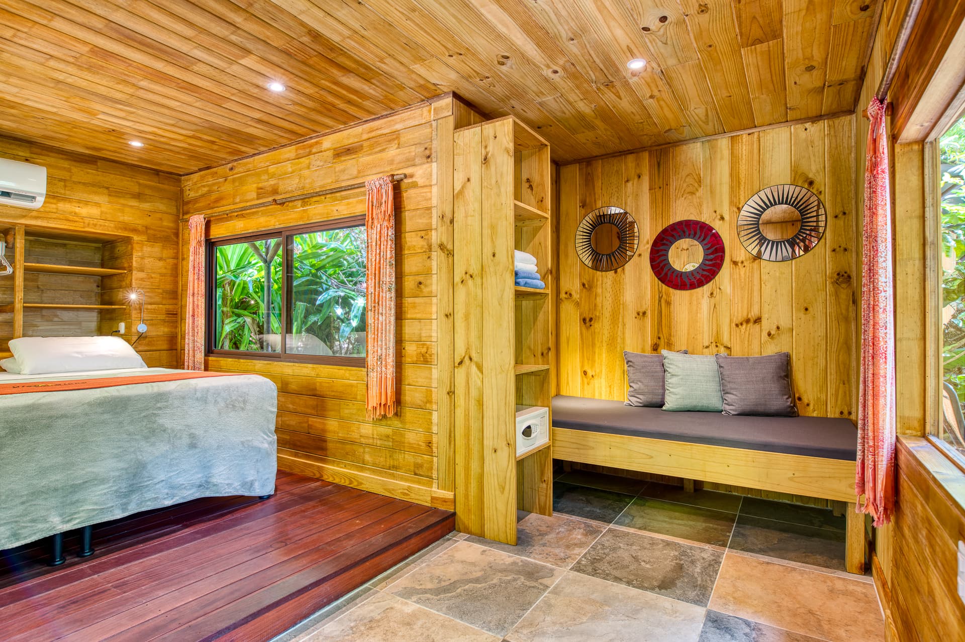 Cabina Room interior with rich hardwood paneling, built-in bench seat, and king bed