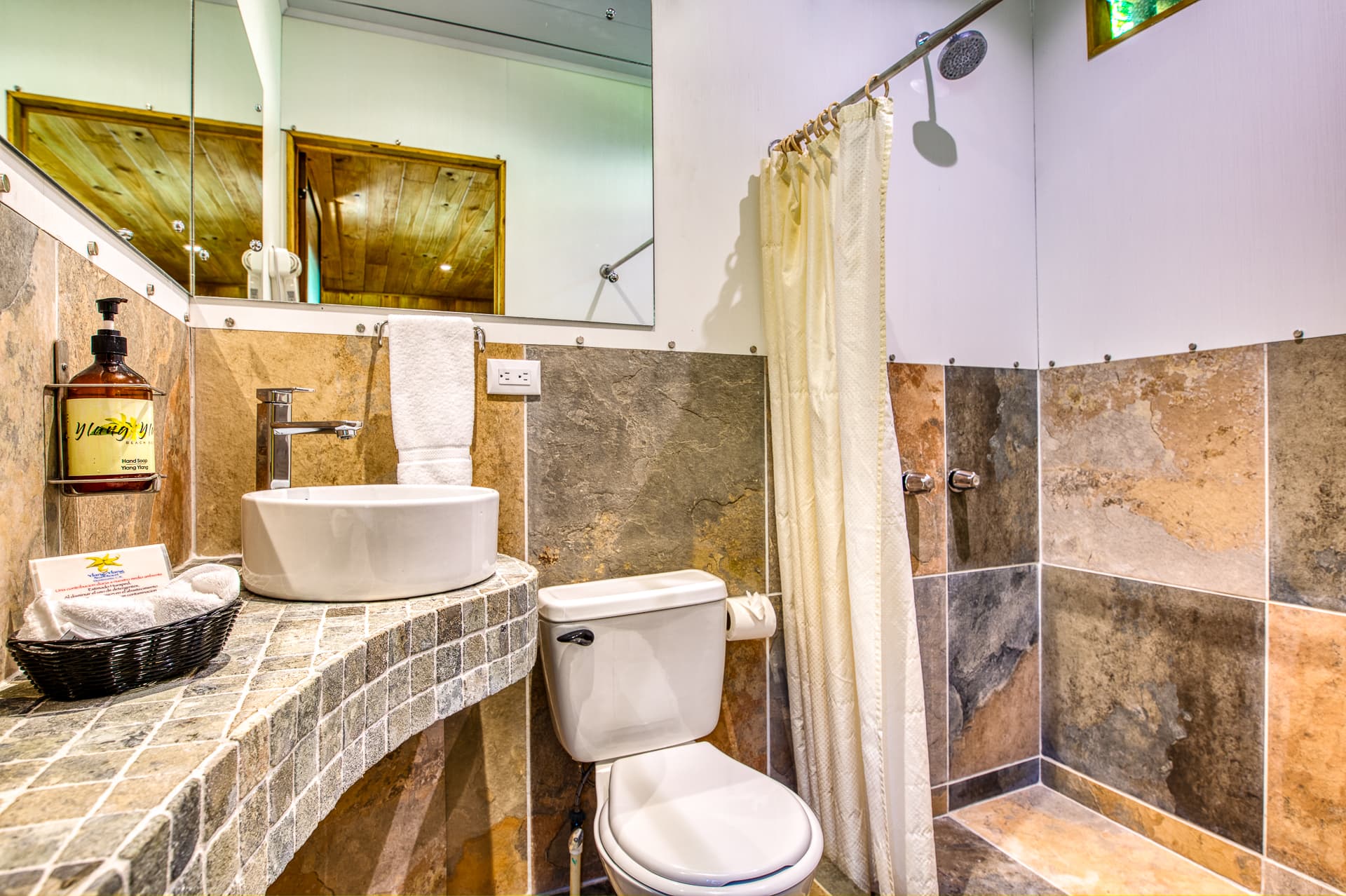 Cabina Room Bathroom with tiled shower, toilet, and tiled vanity with vessel sink
