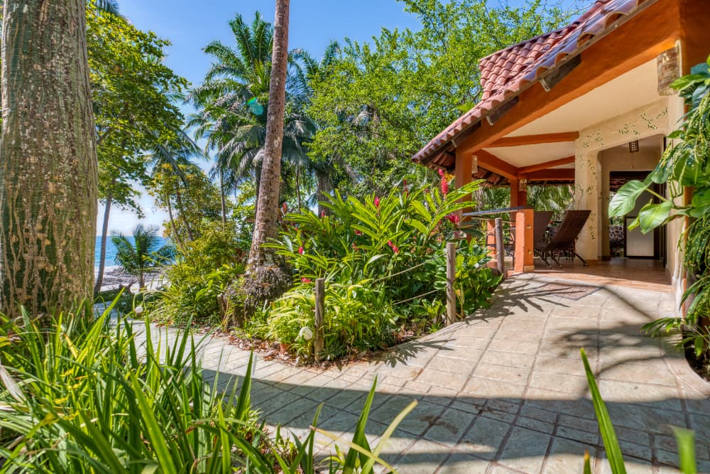 A private bungalow in the jungle with a stone walkway leading down to the beach and ocean
